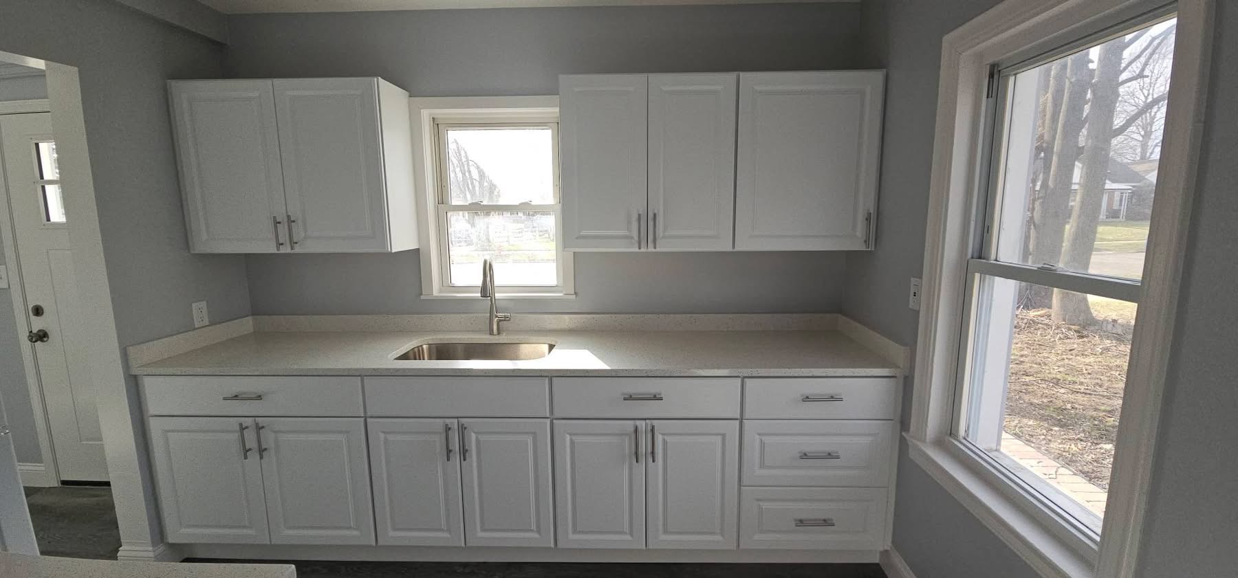 Renovated kitchen — white cabinets with quartz countertops