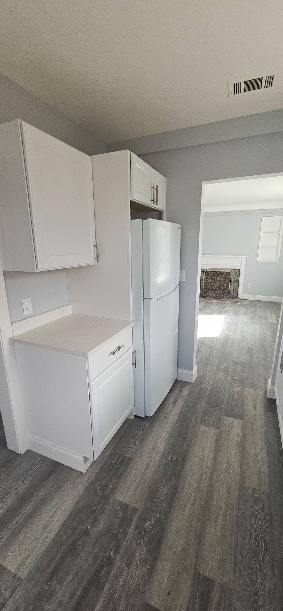 Kitchen with hardwood floors and living area beyond